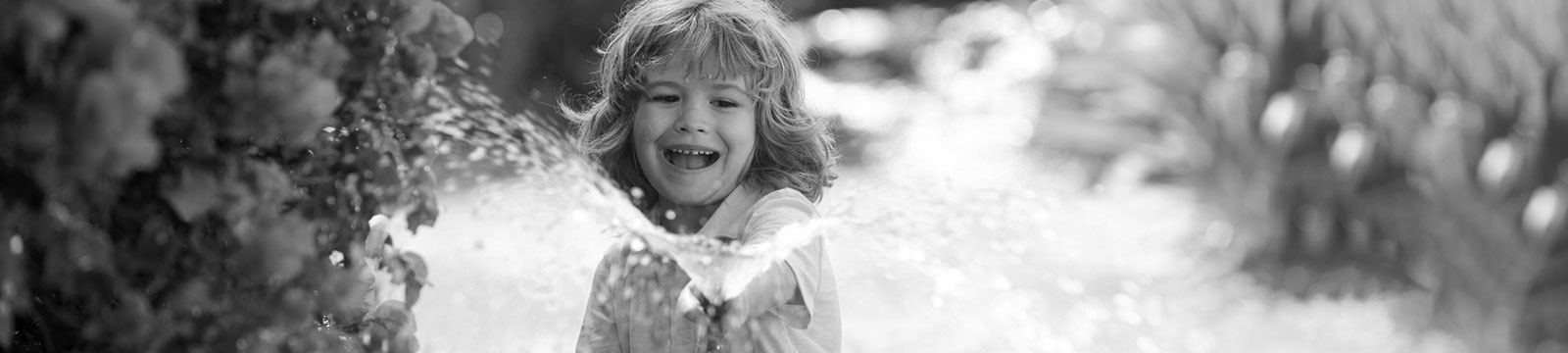 little boy watering flowers